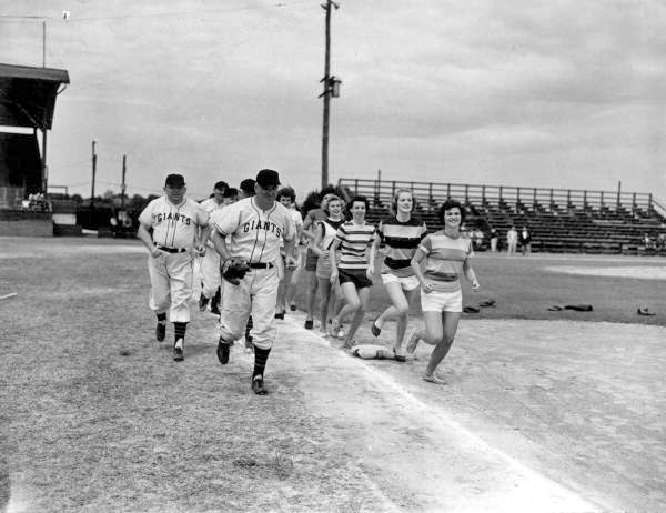 Members of New York Giants and Sanford girls team engage in warmup exercise - Sanford, Florida 
