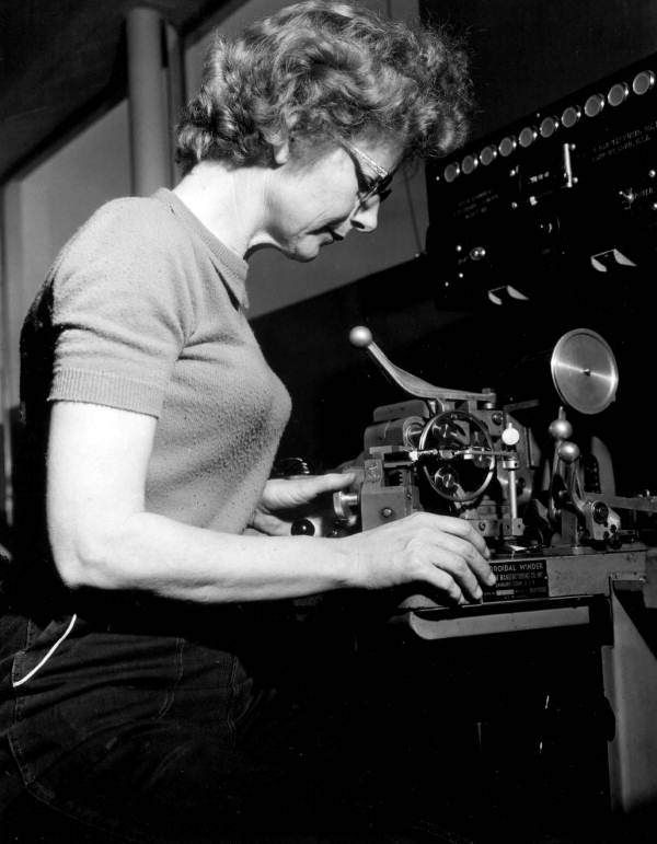 Mrs. Beulah Conley operates toroid coil winding machine.