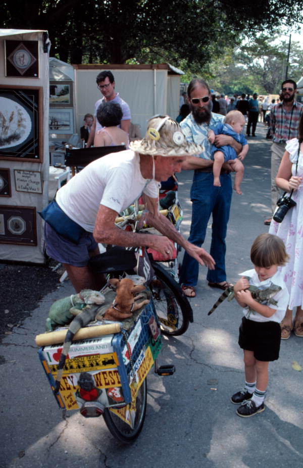 "Iguana Man" allowing small boy to hold his pet - Key West, Florida