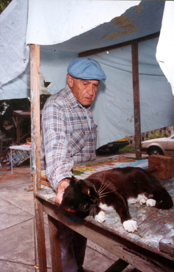 Mario Sanchez taking a break from his art work to pet his cat - Key West, Florida