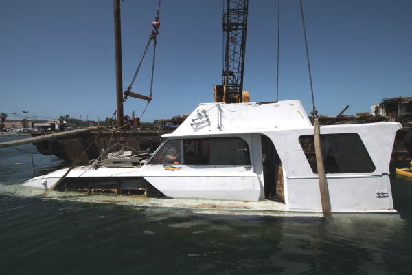 Close-up view of sunk yacht being retrieved by crane from Garrison Bight Marina - Key West, Florida