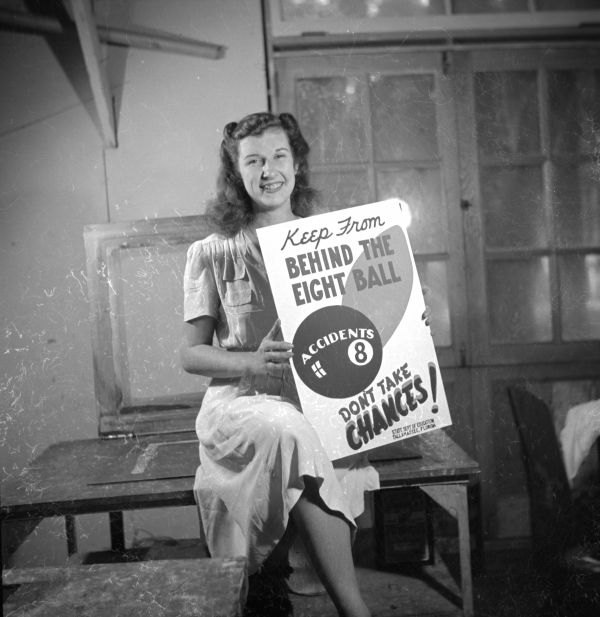 Young woman posing with a completed safety poster at the NYA's Camp Roosevelt - Ocala, Florida