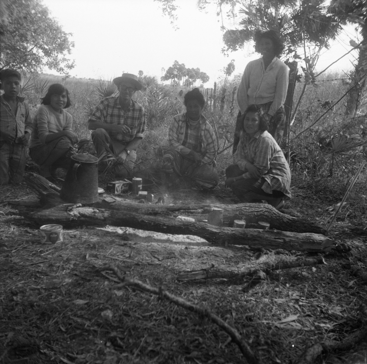 Six people on a cattle roundup waiting by the campfire for coffee