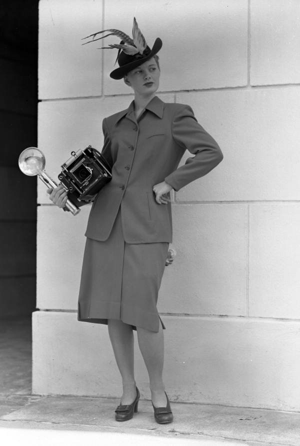Model holding a Speed Graphic camera.