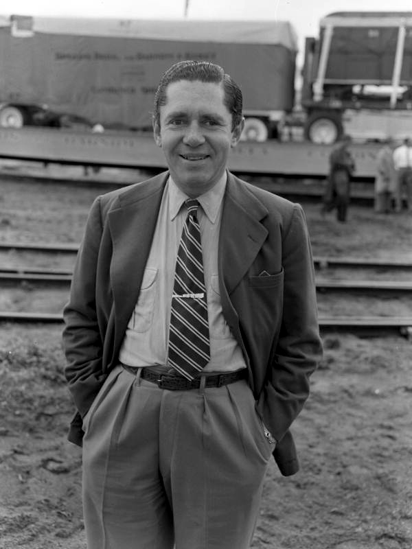 Portrait of John Ringling North, vice-president of the Ringling Circus, standing near the train leaving the winter quarters in Sarasota, Florida.