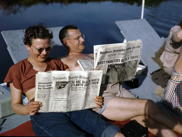 Mabel and Archie aboard the shantyboat "Lazy Bones," reading of a snowstorm in the northeast U.S.