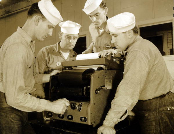 Naval Photography School instructor showing students how to use equipment at NAS Pensacola.