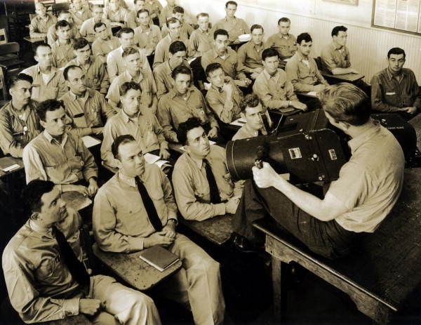Naval Photography School instructor showing aerial camera to class at NAS Pensacola.