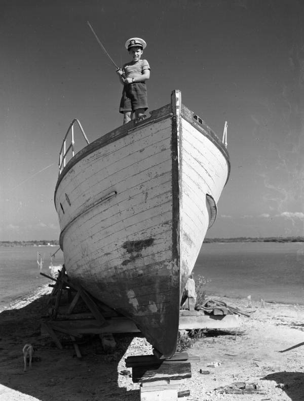 Photographer's son William "Billy" Steinmetz with samurai sword and Joe's naval cap on an old Ringling yacht at Dixon Boat Works in Sarasota, Florida.