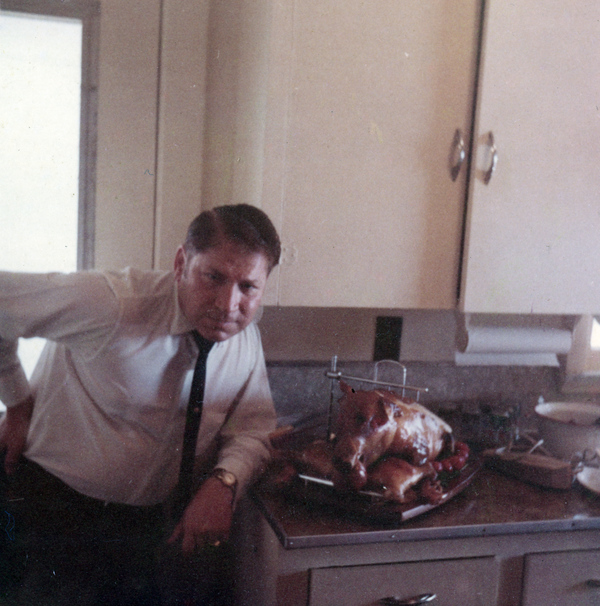 Norm Swain posing next to a Christmas pig at the Koreshan Unity's Rising Tide Cottage at Fort Myers Beach, Florida.