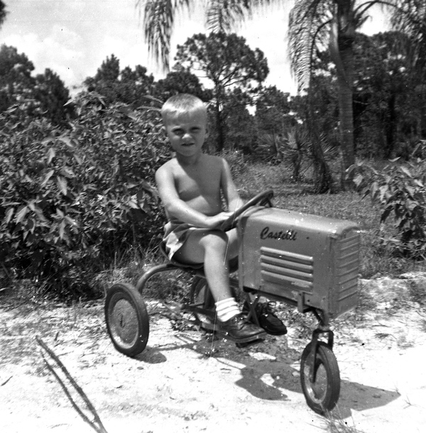 Koreshan boy on a Castelli tractor pedal car.