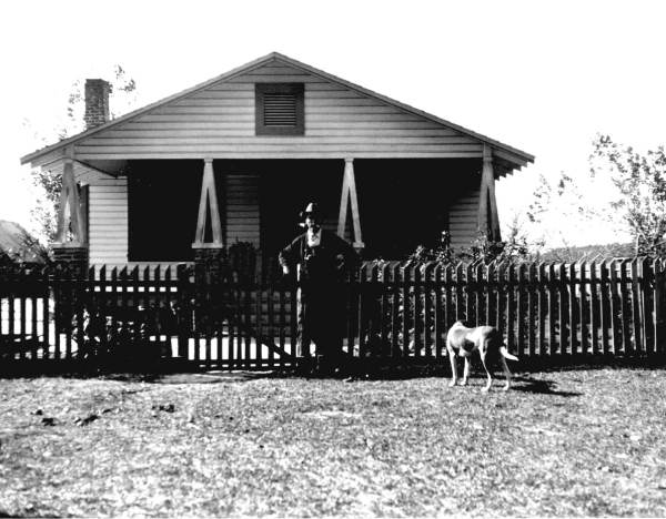 Man and dog standing outside a residence