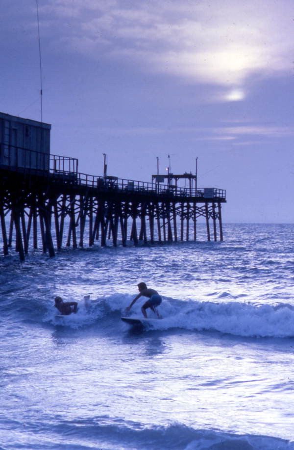 People surfing next to the Canaveral Pier in Cocoa Beach, Florida.