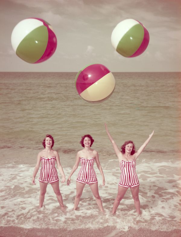 Women modeling bathing suits at the beach.