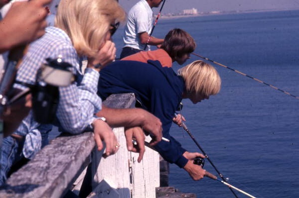 Close-up view of people fishing from the pier at Jacksonville Beach.