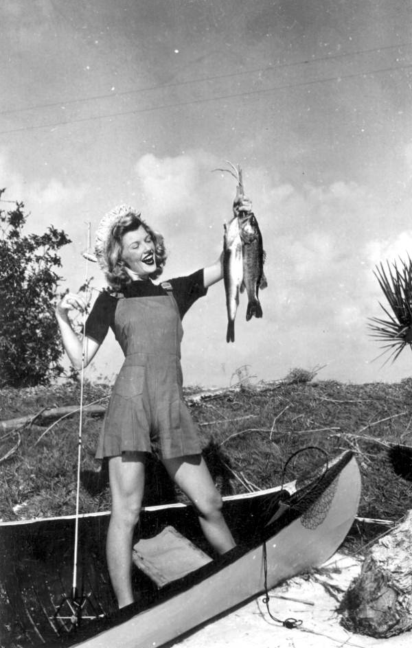 Helen Hatfield showing off two big-mouthed bass she caught while fishing at Cypress Gardens