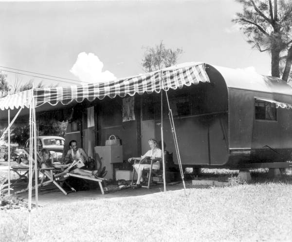 Mr. and Mrs. H. B. Straight sitting under the awning by their trailer - Sarasota, Florida .