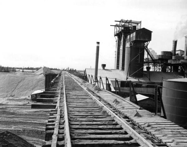 High stacks of phosphate form shoulders for elevated railroad at IMC.