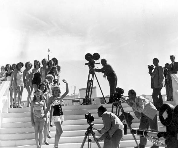 Newsreel cameramen photographing beauty contest on pool steps at the North Shore Hotel - Miami Beach, Florida.