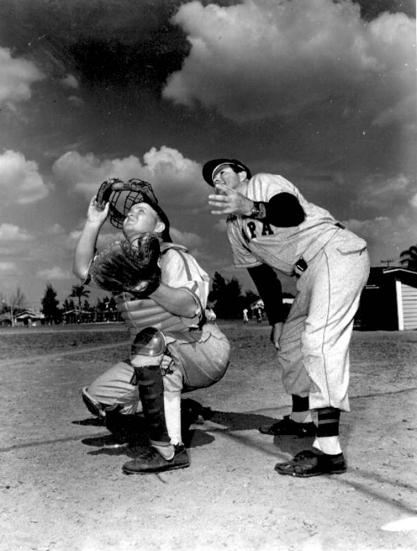 Catcher Stanley Friedman eyes foul fly, instructor Joe Abreu alongside - Tampa, Florida