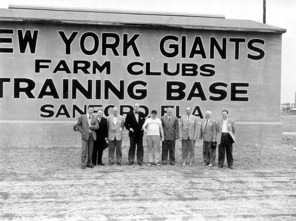 Legislators in front of a sign at the Giant's farm club camp - Sanford, Florida