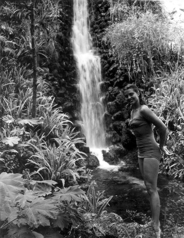 Unidentified woman stands near a waterfall at Rainbow Springs - Dunnellon, Florida