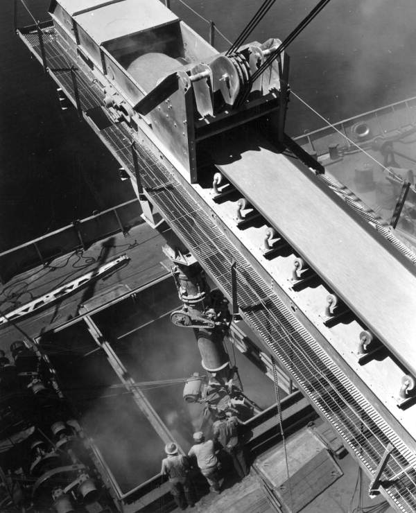 Traveling belt carrying phosphate to telescopic chute at rate of 29 tons per minute and depositing it into ships hold..