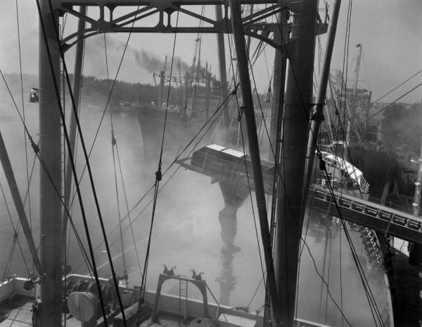 Telescopic chute is lowered into cargo hold to load ship..