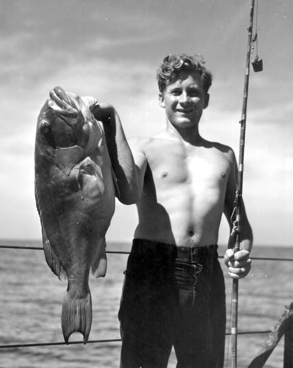 Teenage boy proudly shows off a large grouper catch - Florida Keys, Florida