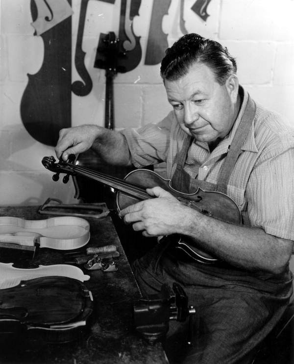 Violin maker Dudley Reed checking a violin for tonal quality.