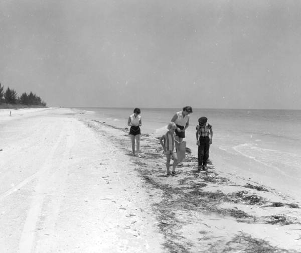 Mrs. Barron with her niece and children beachcombing and collecting shells on the beach - Sanibel Island, Florida.