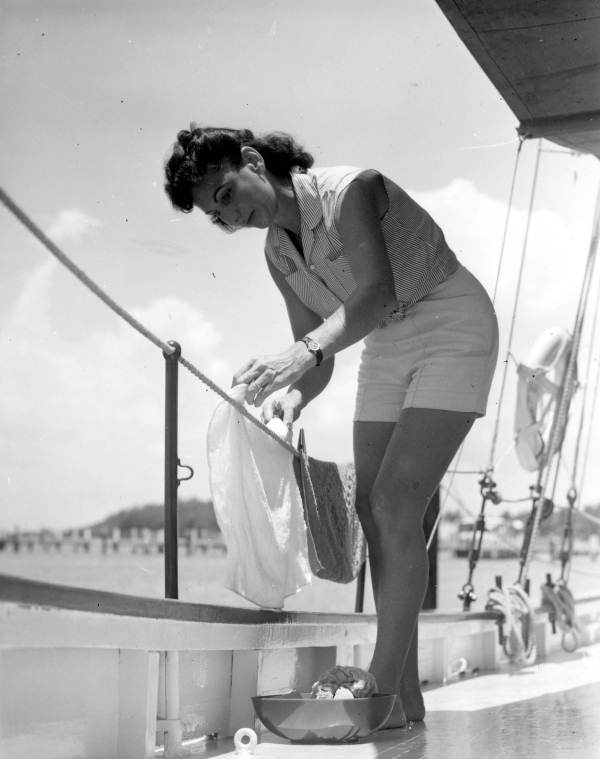 Woman hangs clothes to dry on a houseboat - Fort Lauderdale, Florida
