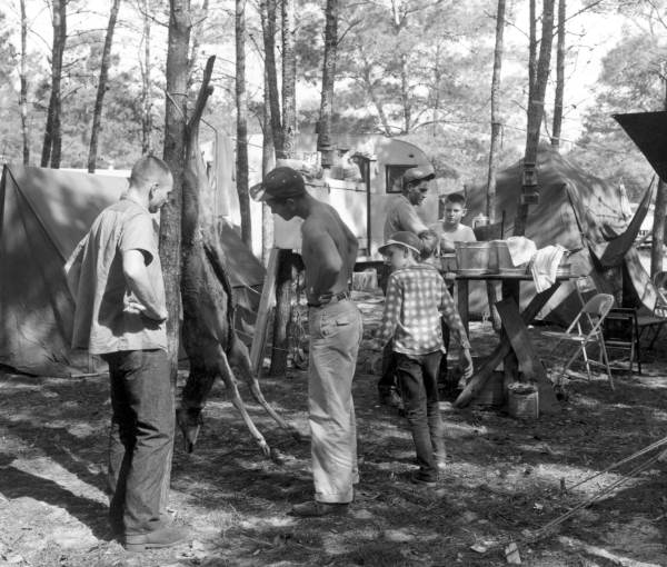 Campers inspect one of the first deer killed during hunting season - Umatilla, Florida.