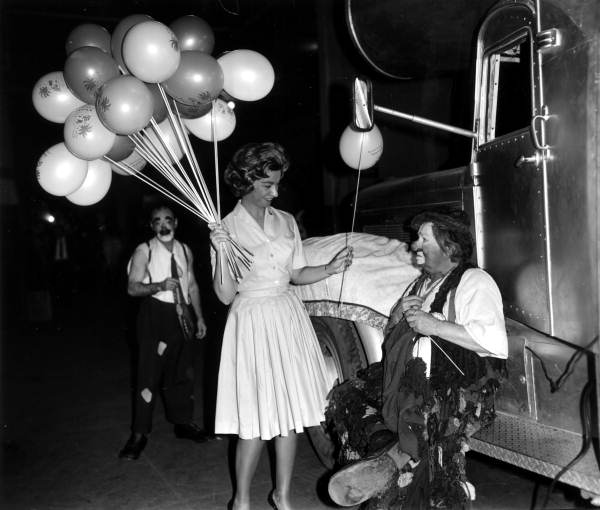 Woman handing a balloon to a clown