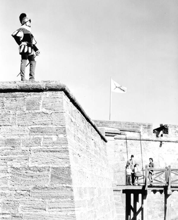 A family on the drawbridge looking up at a costumed Spanish Conquistador - Saint Augustine, Florida.