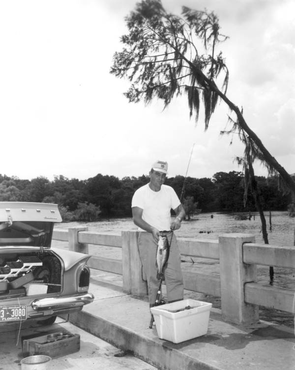 A man holds a fish on the bridge - Dead Lakes, Florida