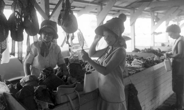 Woman trying on bonnets at the Farmers' Street Market - Lakeland, Florida.