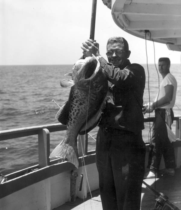 A man proudly holds up his catch of grouper - Destin, Florida.