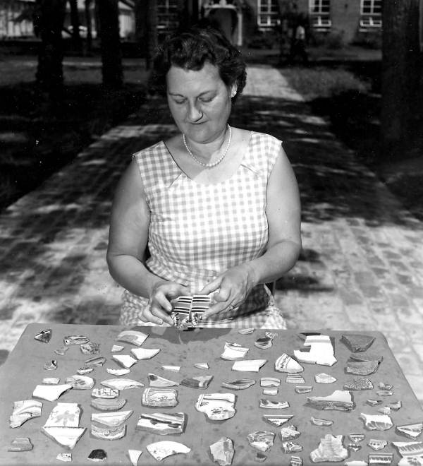 Leora M. Sutton looking over pottery pieces excavated from lots 8 and 9 on Zaragoza Street - Pensacola, Florida.