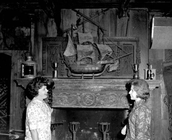 Women standing in front of a fireplace at the Driftwood Inn - Vero Beach, Florida.