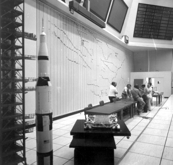 Unidentified men and a model of a rocket and the launch area - Cape Canaveral, Florida