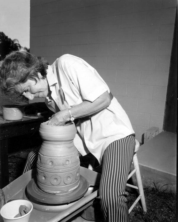 Woman potter making a pot.