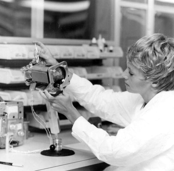 Woman assembling an airplane navigational instrument