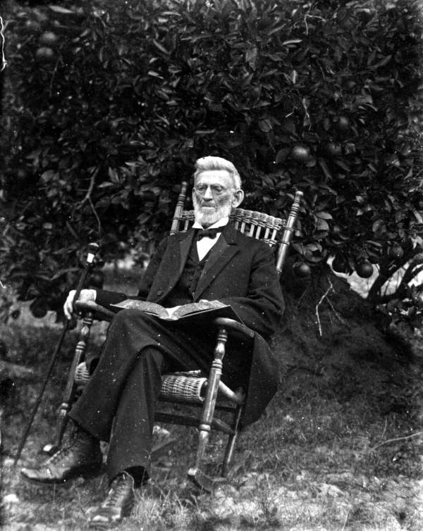 Elderly man in rocker holding book