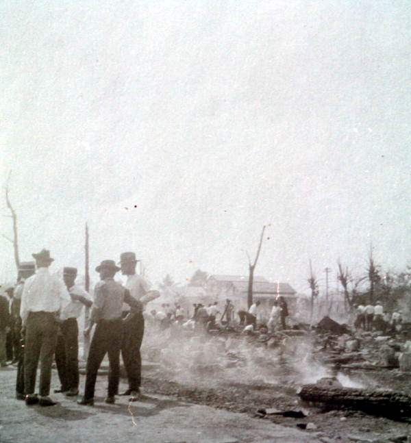 Men huddled together near the remains from the "Great Fire of 1923" - Key West, Florida.