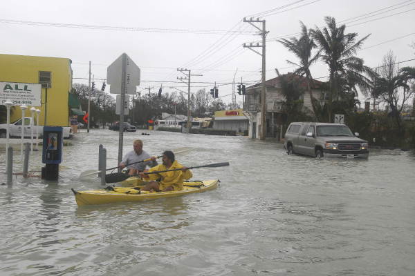 Men kayaking in flood waters on Flagler Avenue - Key West, Florida.