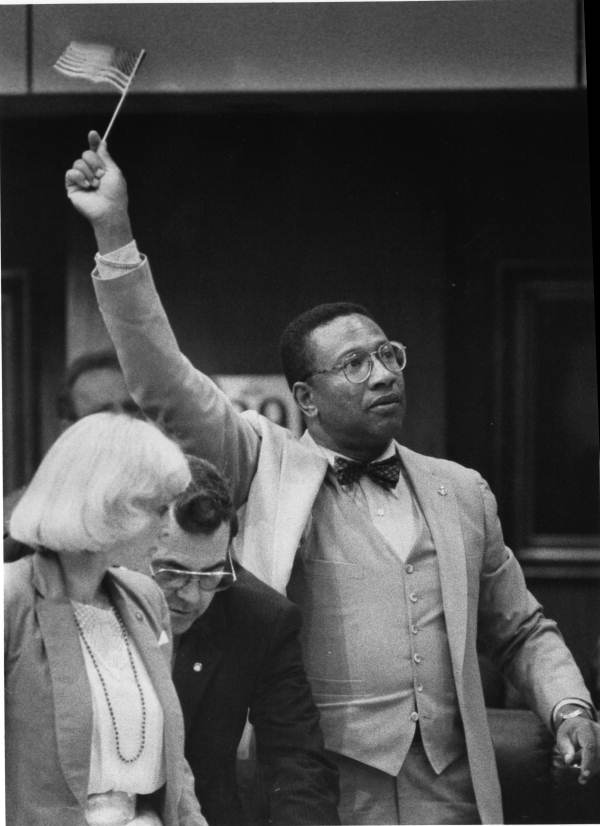 Rep. Alzo Reddick, D-Orlando, waves an American flag during voting - Tallahassee, Florida.