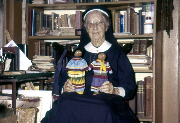 Deaconess Bedell at Glade Cross Mission in Everglades City with Seminole dolls.