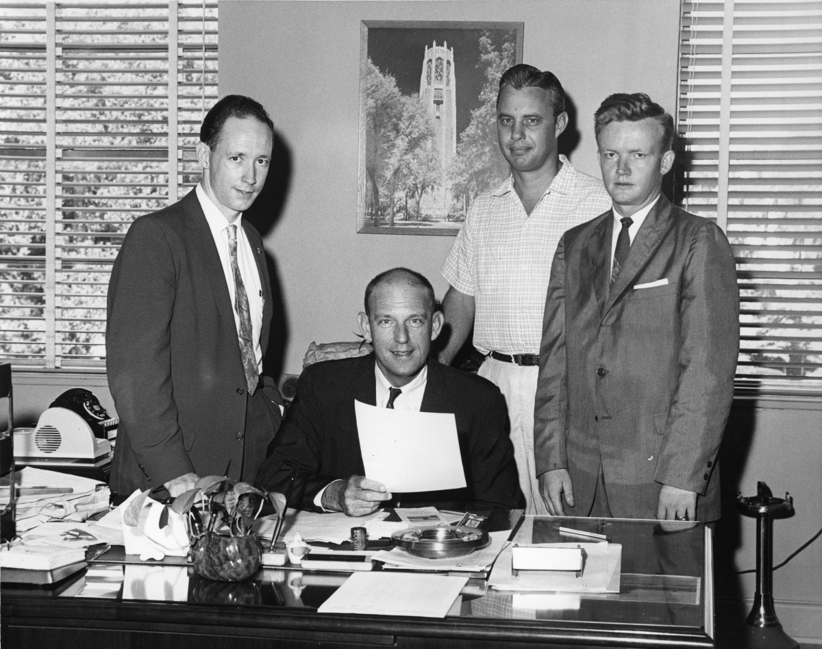 Men gathered around State Board of Conservation director Ernest Mitts in Tallahassee, Florida.