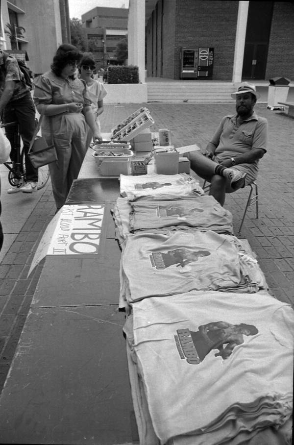 Students look at the sunglasses and Rambo First Blood Part II t-shirts - Tallahassee, Florida.